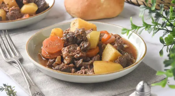 Un reconfortante plato de carne guisada con patatas y zanahorias, servido en un cuenco.
