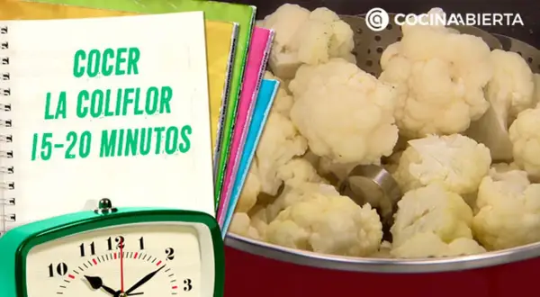 Coliflor cocida en una olla, con un reloj y un cuaderno que indica el tiempo de cocción de la coliflor: 15-20 minutos.