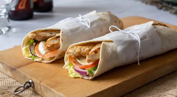 Dos deliciosos wraps de pollo, rellenos de verduras frescas y queso, listos para disfrutar.