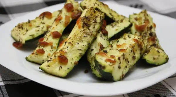 Delicioso calabacín al horno, cortado en bastones y cubierto con queso derretido y hierbas aromáticas.