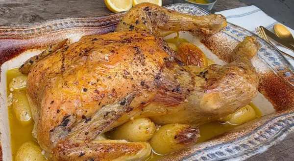 Pollo asado dorado y jugoso, horneado con patatas tiernas en una fuente rústica. ¡Un festín para los sentidos!