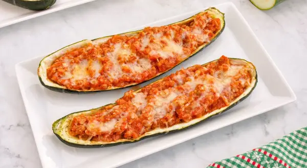 Dos calabacines rellenos de carne y queso gratinado, listos para disfrutar.