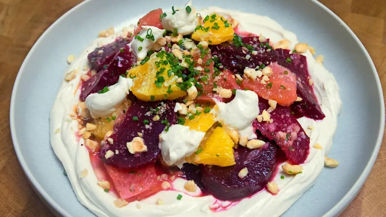 Deliciosa ensalada de remolacha con cítricos, crema y frutos secos picados.