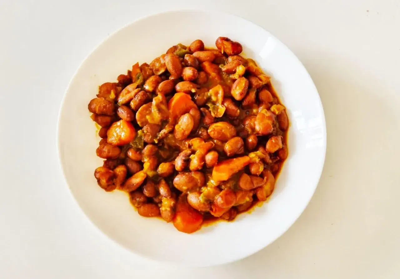 Un plato de judías pintas guisadas con zanahoria y pimientos, un plato casero lleno de sabor.