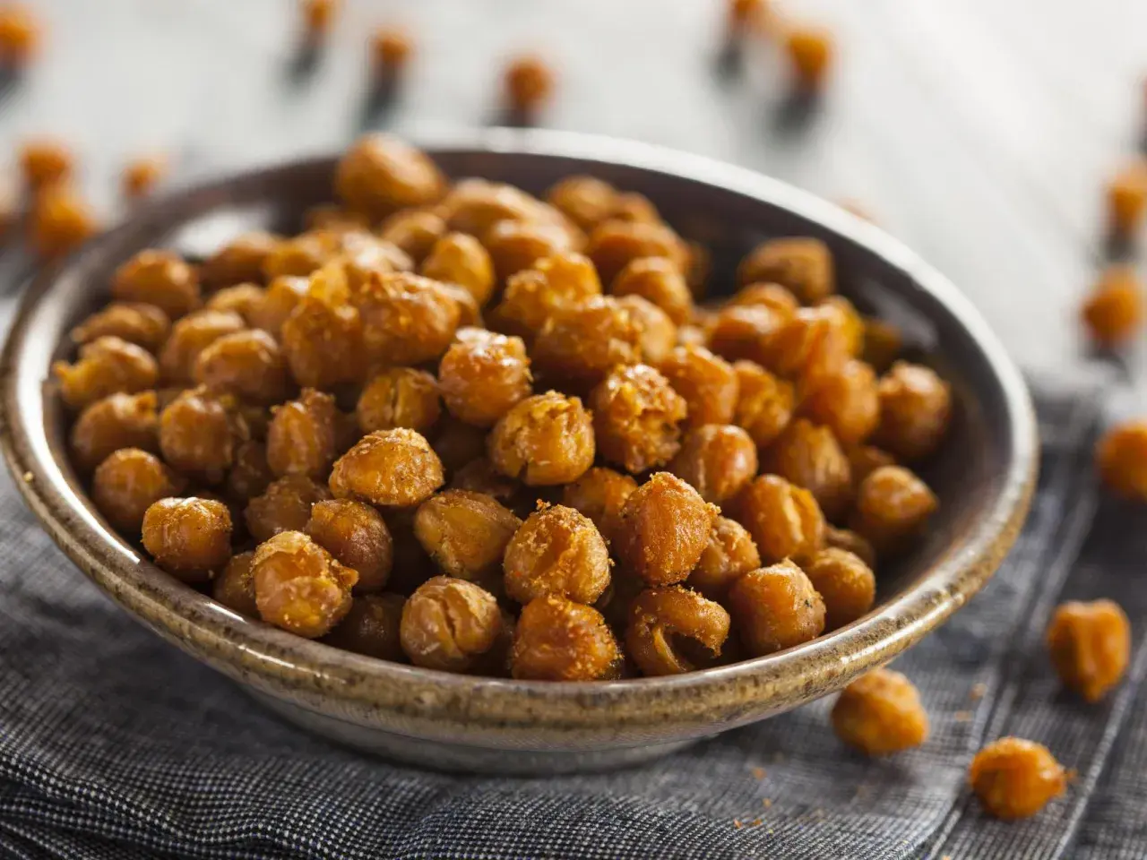 Un tazón lleno de garbanzos fritos dorados y crujientes, perfectos para un aperitivo saludable.