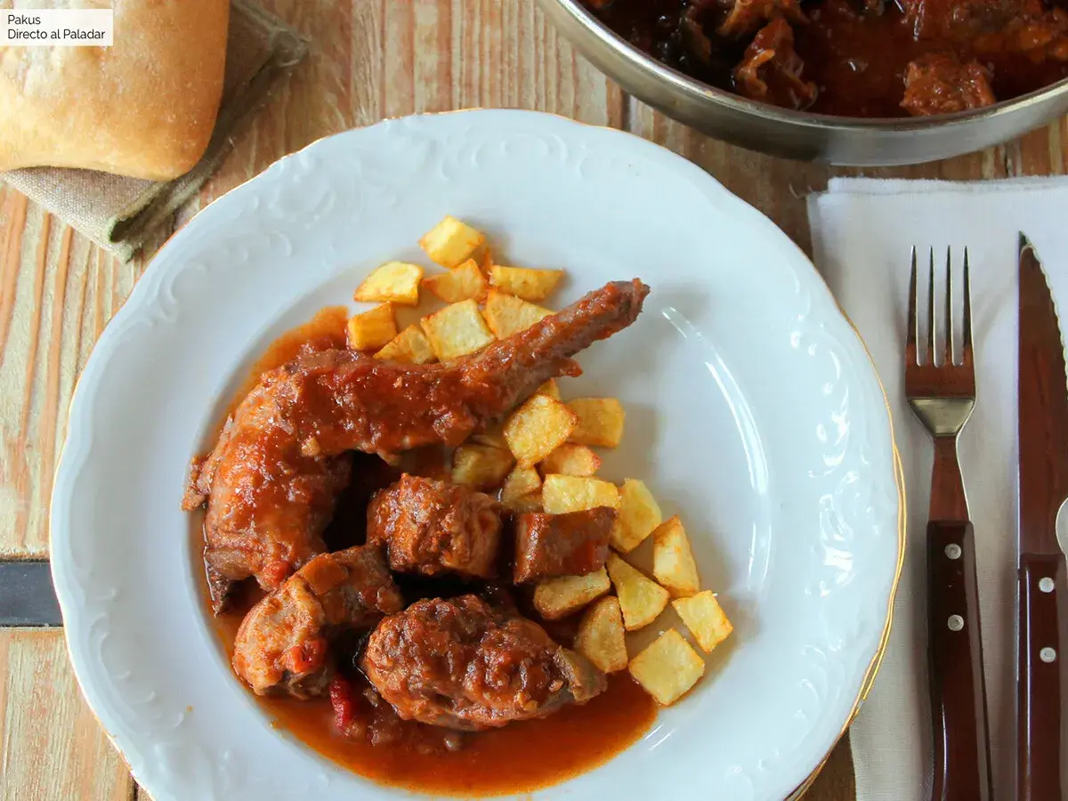 Sabroso conejo guisado en salsa con patatas fritas crujientes. Un plato casero que invita a disfrutar.