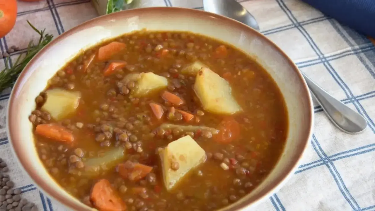 Un tazón humeante de lentejas estofadas Arguiñano, con patatas y zanahorias, listo para disfrutar.