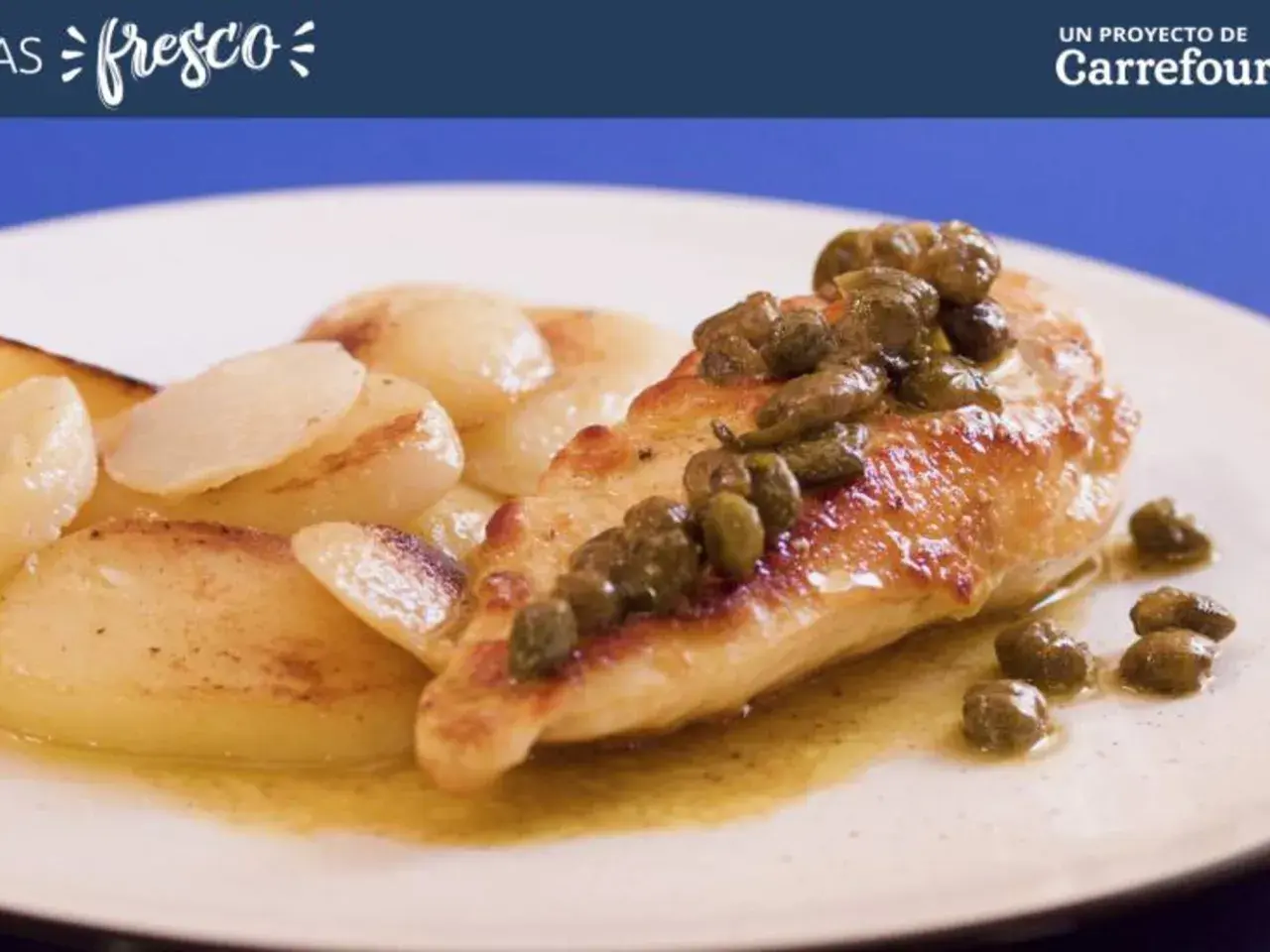 Pechuga de pollo dorada con alcaparras, servida con patatas salteadas en una salsa dorada.