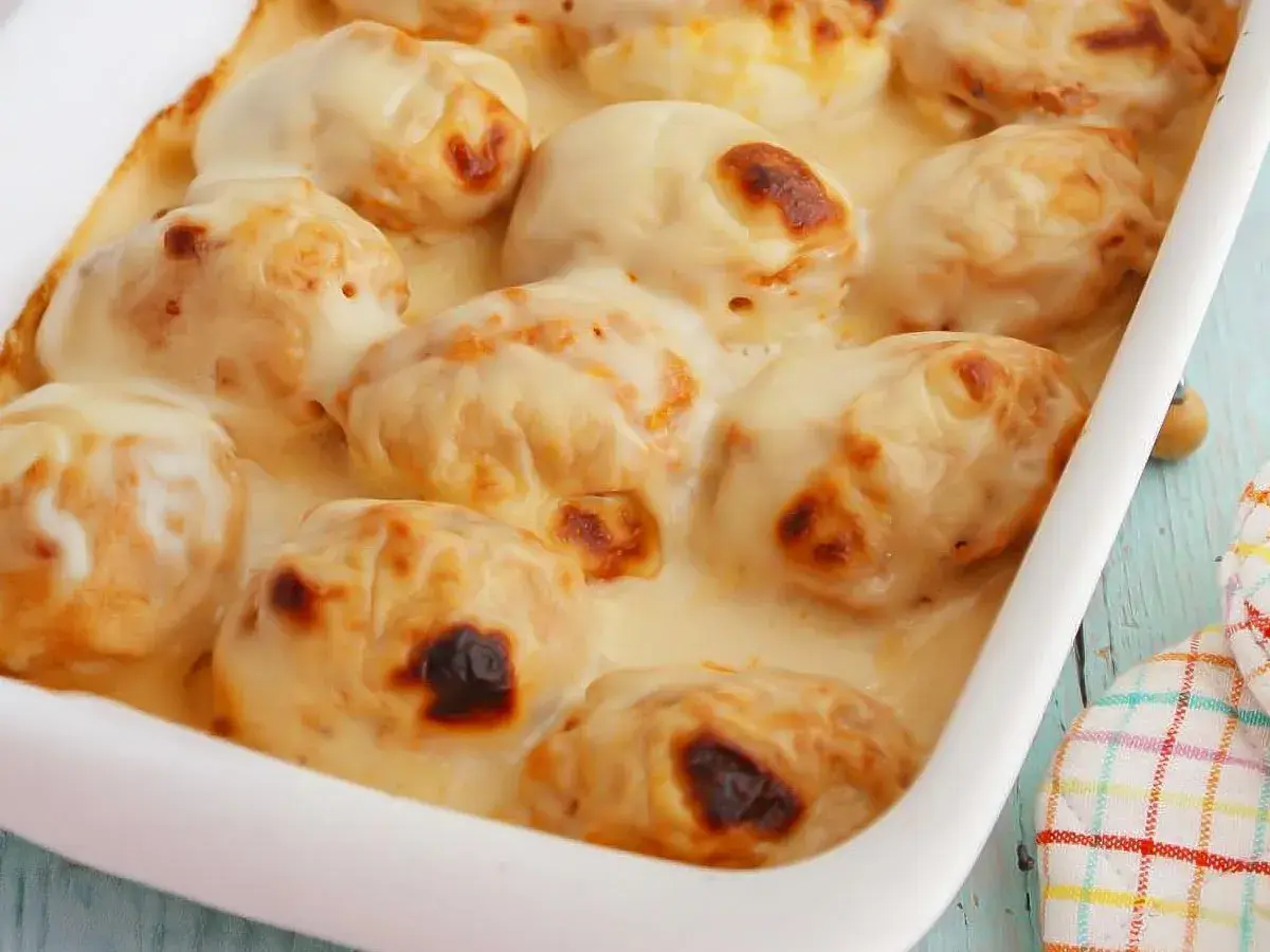 Huevos gratinados con bechamel cremosa, dorados y burbujeantes en una fuente blanca. ¡Un plato reconfortante!