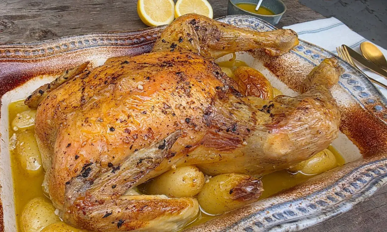 Pollo asado dorado y jugoso, horneado con patatas tiernas en una fuente rústica. ¡Un festín para los sentidos!