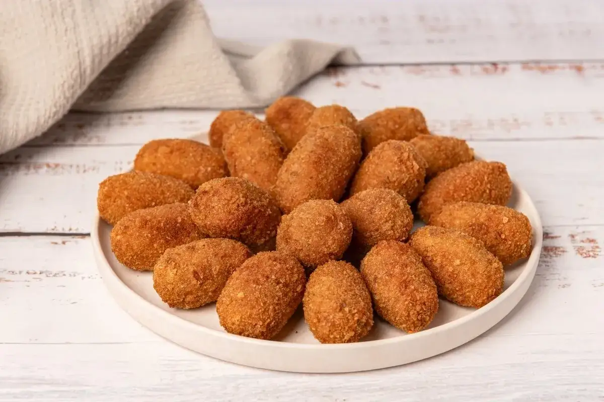 Un plato lleno de crujientes croquetas de puchero, doradas y listas para disfrutar.