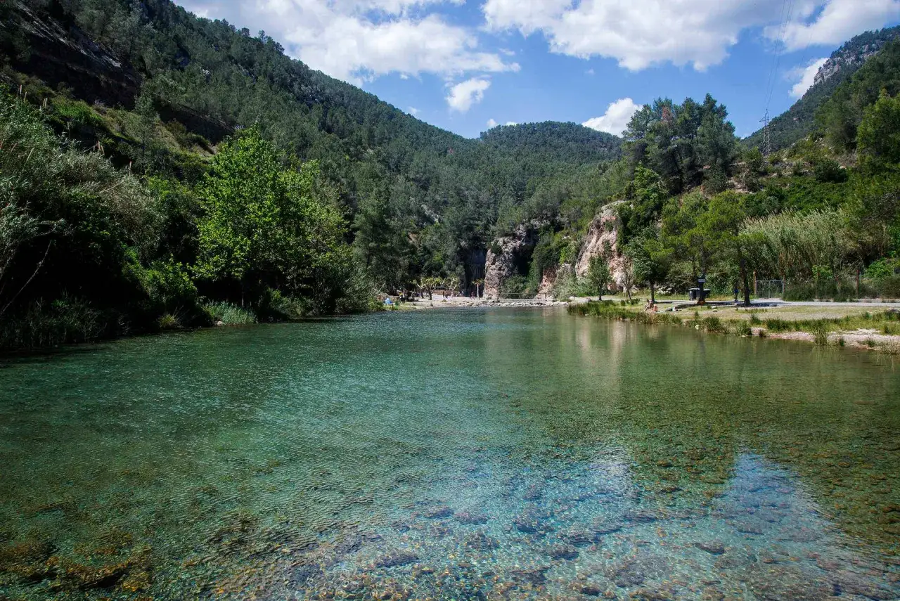 Aguas cristalinas en la rosaleda de Mijares, rodeada de monta&ntilde;as verdes y rocosas. Un lugar id&iacute;lico para disfrutar de la naturaleza.
