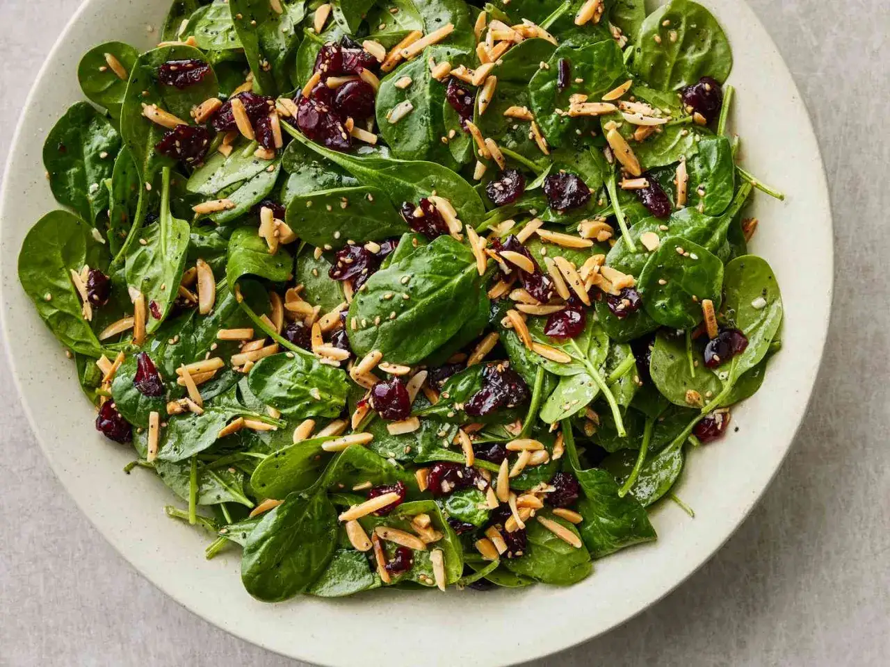 Ensalada de espinacas fresca con ar&aacute;ndanos secos y almendras fileteadas.