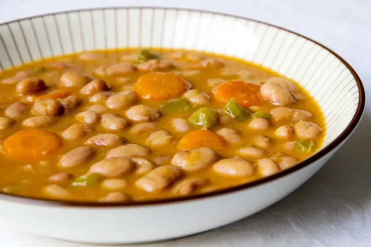 Un reconfortante plato de judías pintas con zanahoria y pimiento verde en un cuenco.