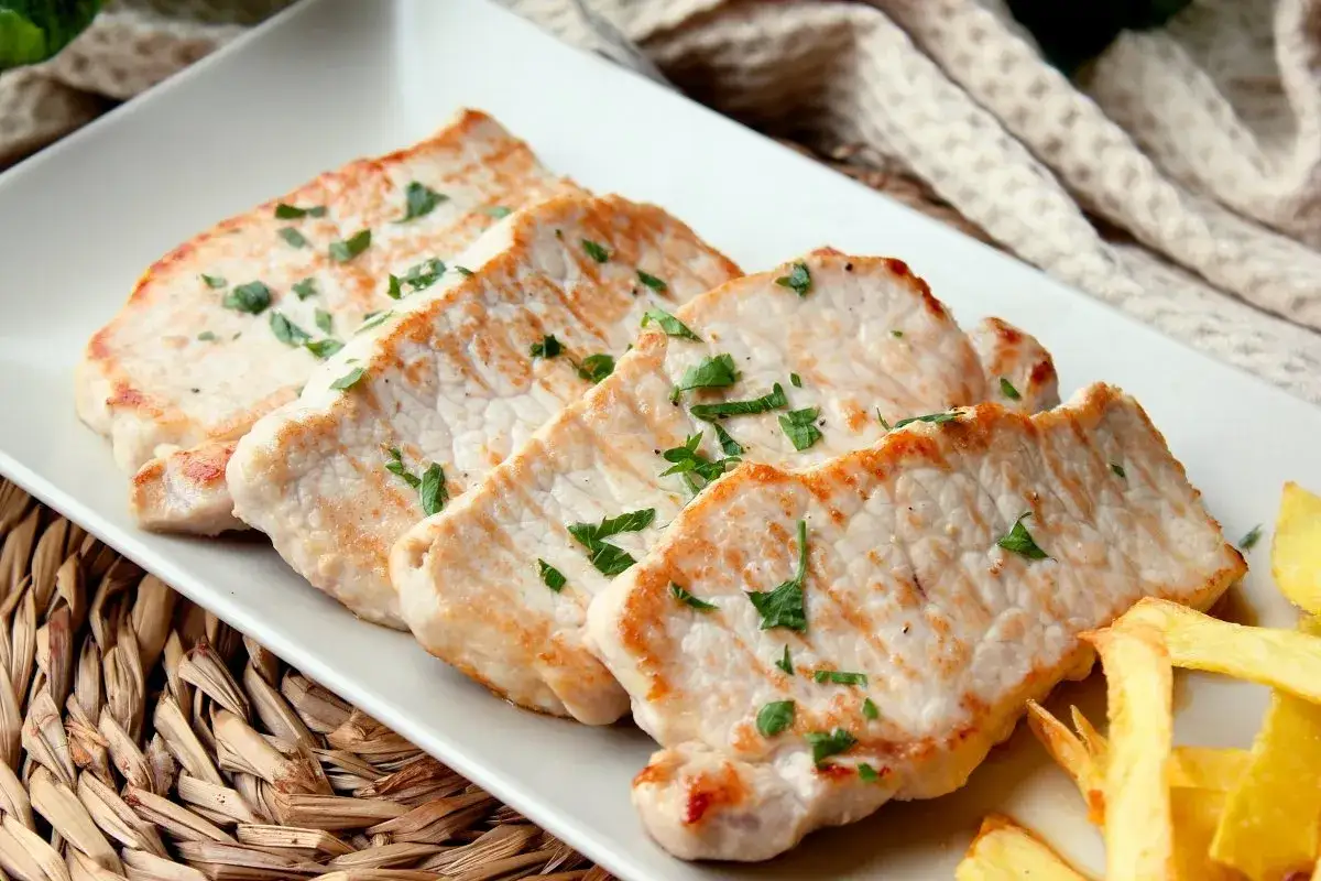 Cuatro filetes de lomo adobado, dorados y jugosos, espolvoreados con perejil fresco, acompa&ntilde;ados de patatas fritas.