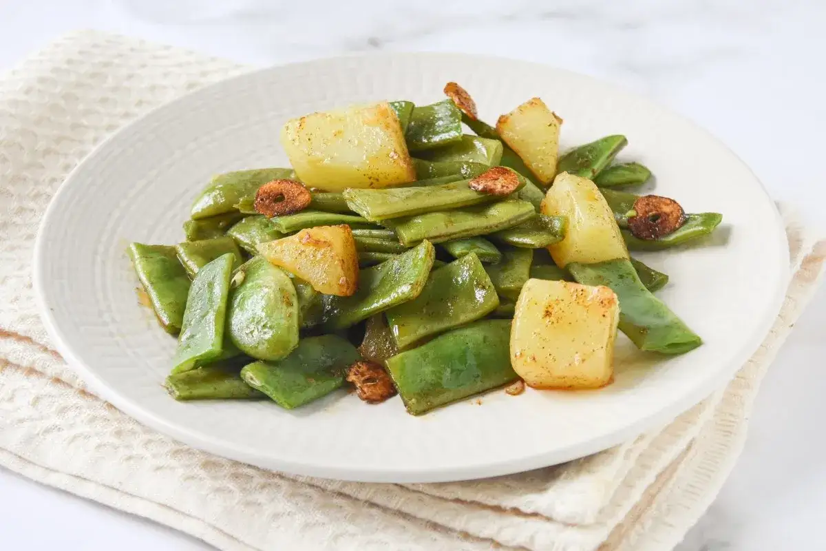 Un plato de jud&iacute;as verdes con patatas, salteadas con ajo crujiente. Un acompa&ntilde;amiento sencillo y delicioso.