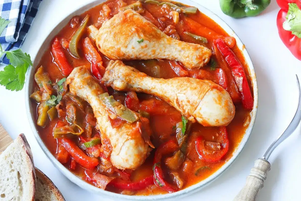 Sabroso pollo al chilindr&oacute;n con pimientos rojos y verdes en una salsa de tomate.
