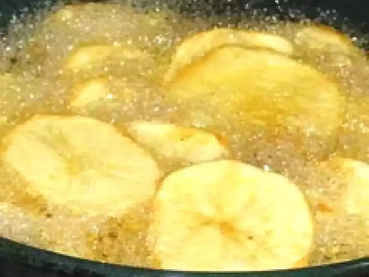 Rodajas de patata dorándose en aceite burbujeante, perfectas para tus recetas con patatas caseras.