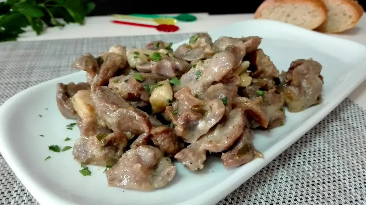 Mollejas de pollo en salsa cremosa, un plato sabroso y tierno, adornado con perejil fresco.