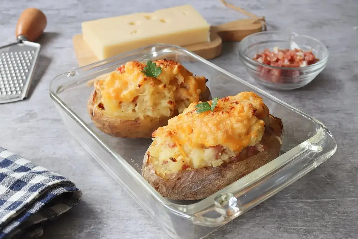 Dos patatas rellenas gratinadas con queso y perejil, listas para disfrutar.