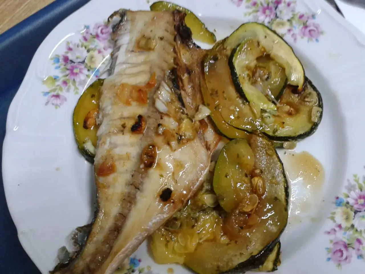 Pescado al horno con rodajas de calabac&iacute;n, todo ba&ntilde;ado en una salsa dorada y arom&aacute;tica.