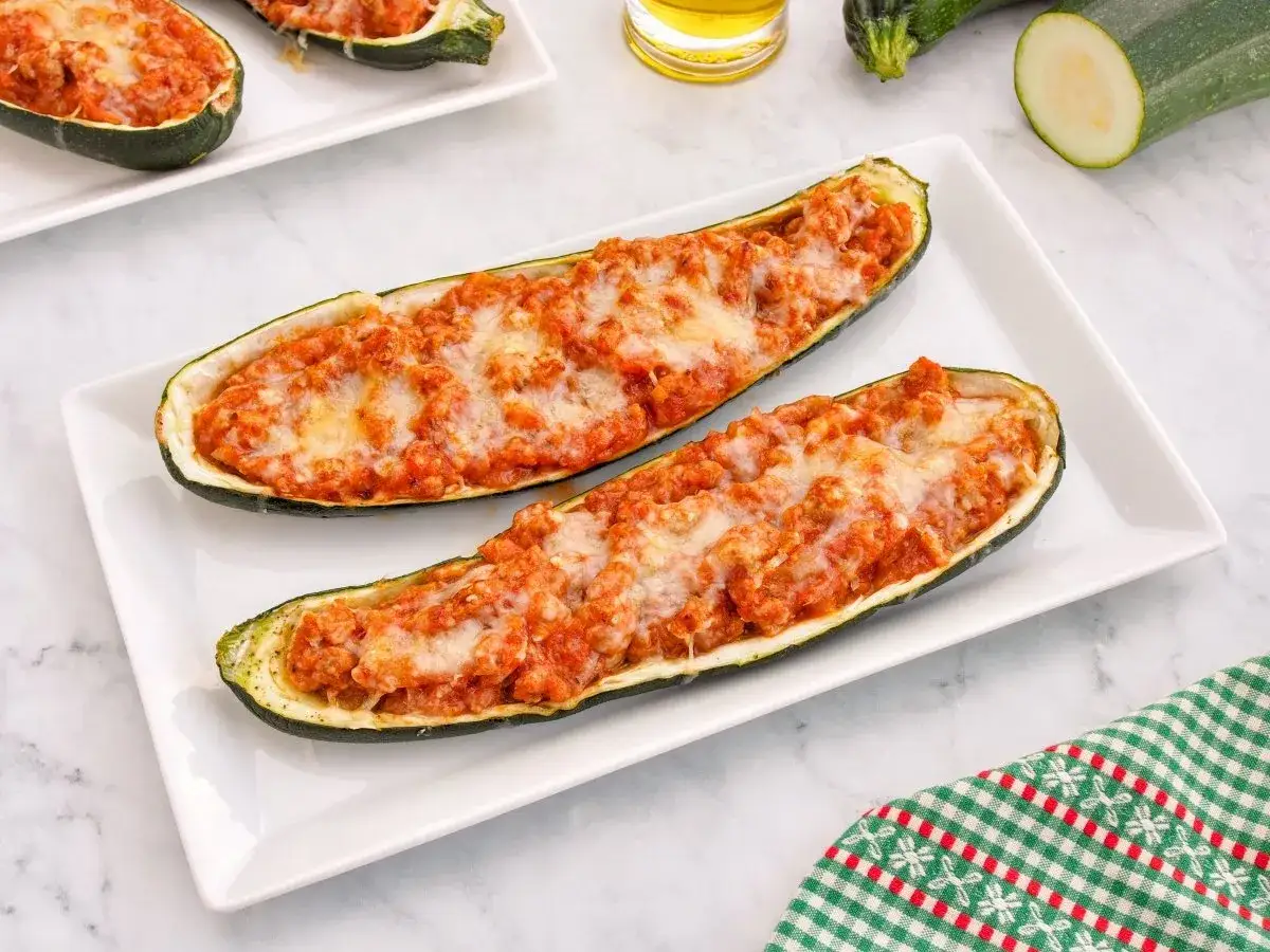 Dos calabacines rellenos de carne y queso gratinado, listos para disfrutar.
