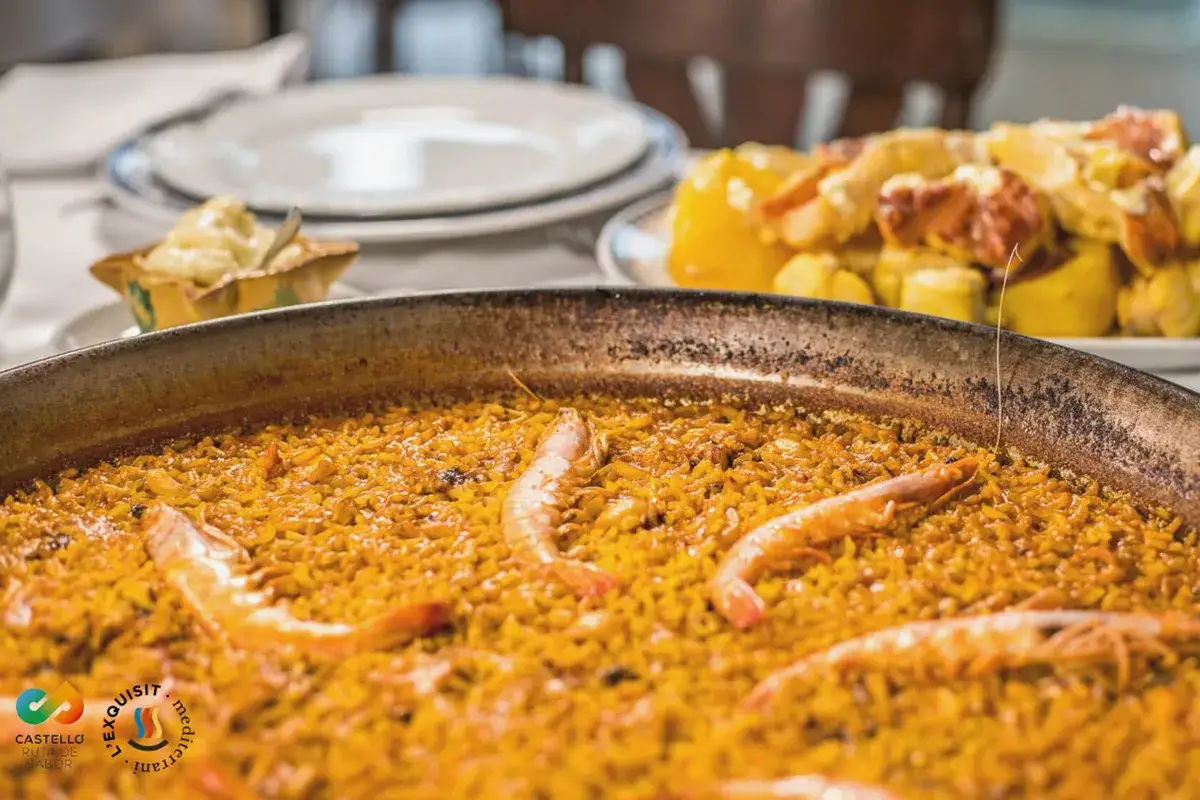 Paella marinera, un plato emblem&aacute;tico de la comida t&iacute;pica de Castell&oacute;n, con gambas y arroz dorado.