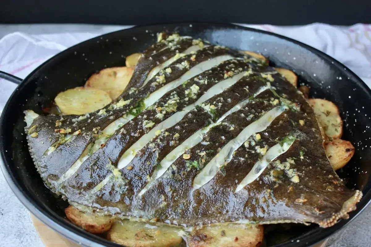 Rodaballo al horno con patatas, un plato principal jugoso y lleno de sabor, listo para disfrutar.