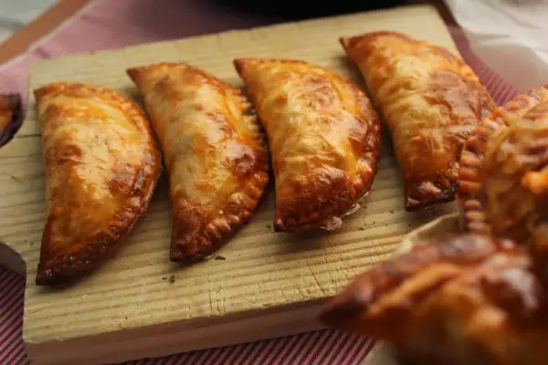 Cuatro empanadillas al horno doradas y crujientes, listas para disfrutar.