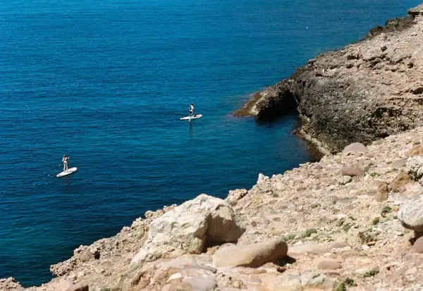 Dos personas hacen paddle surf en aguas turquesas, una actividad genial que ver en Alcossebre con niños.