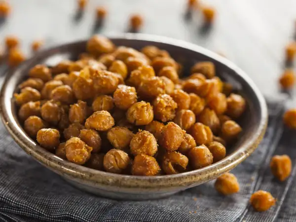 Un tazón lleno de garbanzos fritos dorados y crujientes, perfectos para un aperitivo saludable.