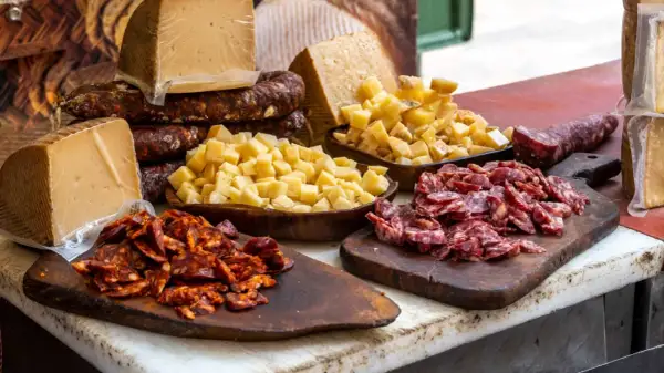 Tabla con quesos y embutidos, incluyendo un delicioso tartar de salchichón, listo para degustar.