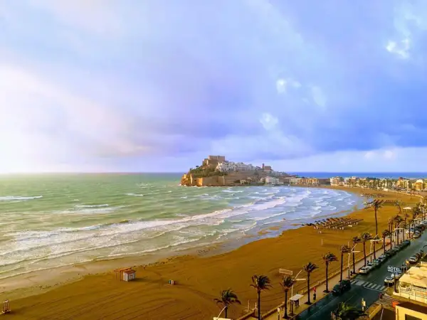 Vista panorámica de la playa del Russo en Peñíscola, con el castillo al fondo y el mar Mediterráneo.