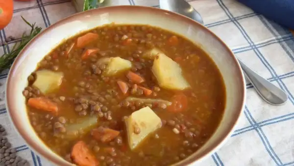 Un tazón humeante de lentejas estofadas Arguiñano, con patatas y zanahorias, listo para disfrutar.