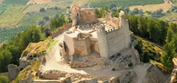 El imponente castillo de Xivert se alza sobre una colina, rodeado de vegetación y campos cultivados. Sus ruinas cuentan historias de batallas y épocas pasadas.