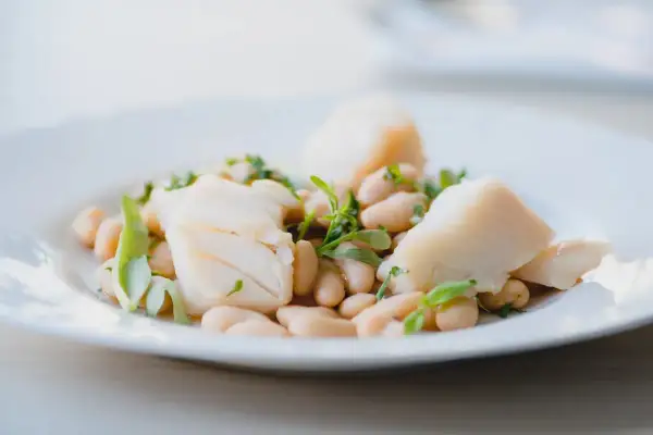 Deliciosa ensalada de bacalao con tiernas judías blancas y hierbas frescas. Un plato ligero y sabroso.