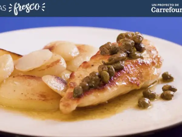 Pechuga de pollo dorada con alcaparras, servida con patatas salteadas en una salsa dorada.