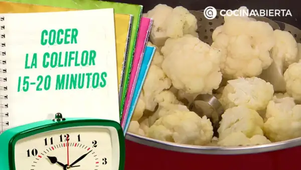 Coliflor cocida en una olla, con un reloj y un cuaderno que indica el tiempo de cocción de la coliflor: 15-20 minutos.