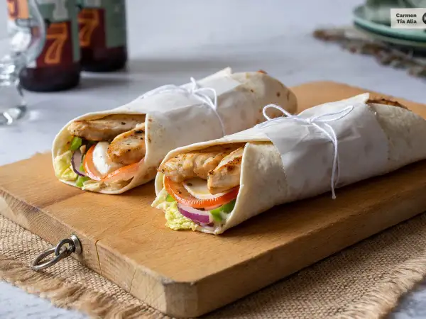 Dos deliciosos wraps de pollo, rellenos de verduras frescas y queso, listos para disfrutar.